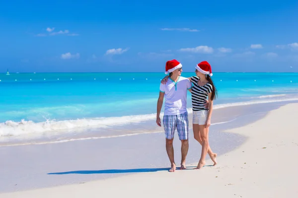 Casal feliz vestindo chapéu de Papai Noel na praia do Caribe — Fotografia de Stock