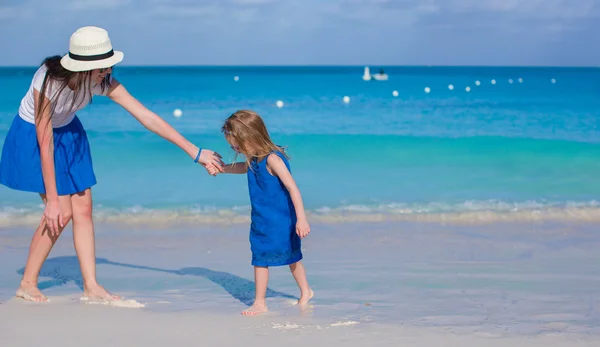 年轻美丽的母亲和她可爱的小女儿在热带海滩玩得很开心 — 图库照片