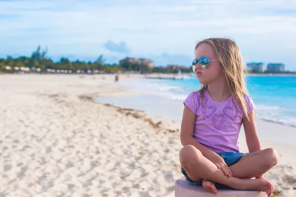 Urocza dziewczynka siedzi w pozycji lotosu na egzotycznej plaży — Zdjęcie stockowe