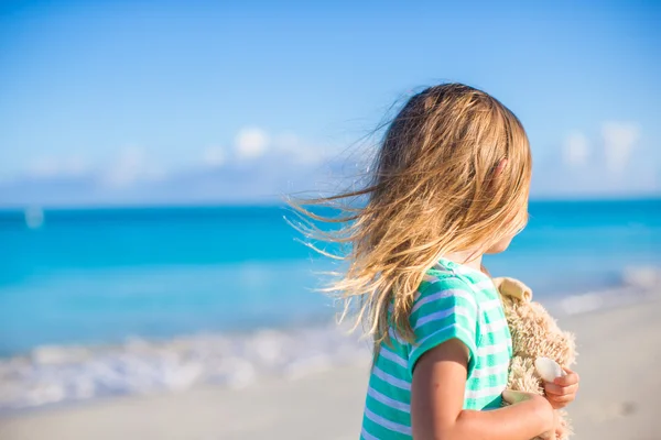 Bedårande liten flicka med sin favoritleksak på tropisk strandsemester — Stockfoto