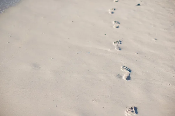 Human footprints on white sand beach — Stock Photo, Image