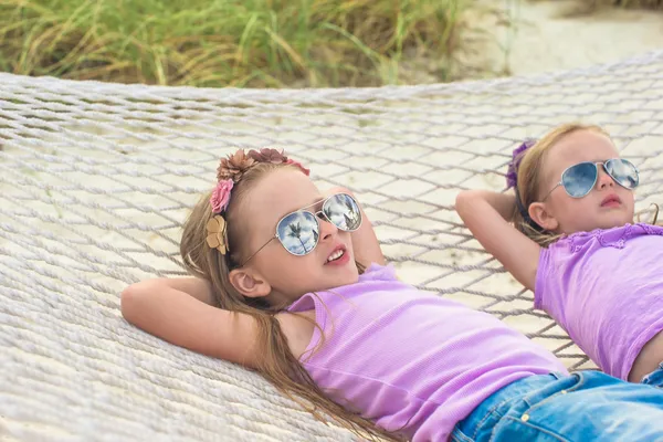 Niñas lindas relajándose en hamaca en vacaciones de verano —  Fotos de Stock