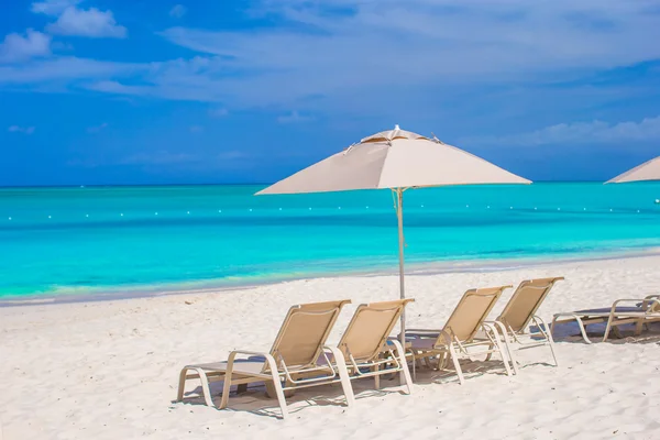 Ombrellone bianco e lettini sulla spiaggia tropicale — Foto Stock