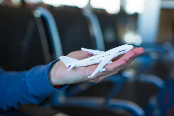 Small airplane model on male hand inside a large aircraft — Stock Photo, Image