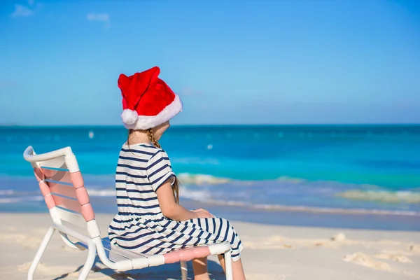 Schattig meisje dragen KERSTMUTS op tropisch strand — Stockfoto