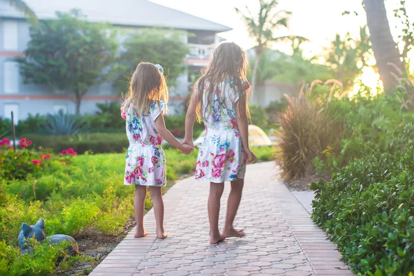 Adorable little girls in exotic resort at sunset — Stock Photo, Image