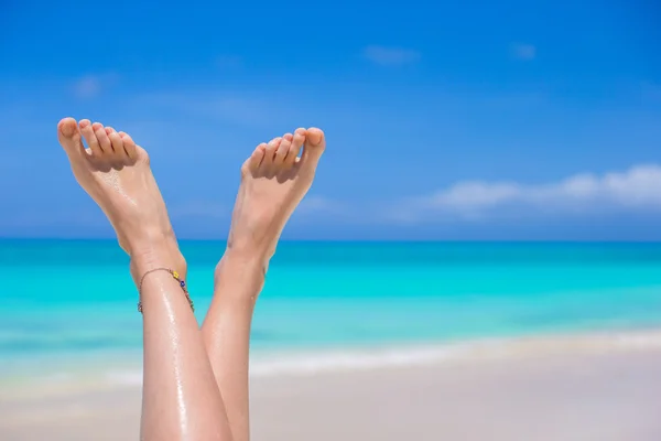Kobiece nogi na białej, piaszczystej plaży z bliska — Zdjęcie stockowe