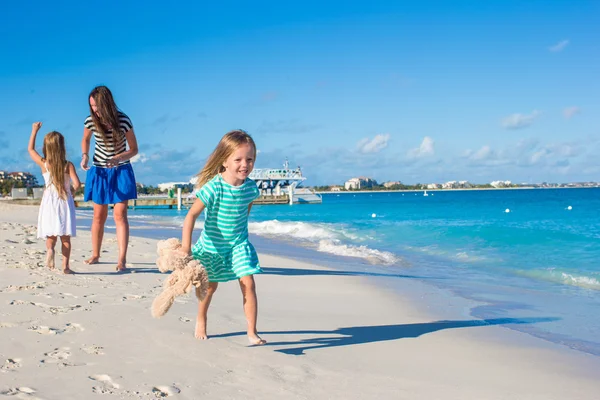 Mutter und ihre kleinen Töchter amüsieren sich an sonnigen Tagen am exotischen Strand — Stockfoto
