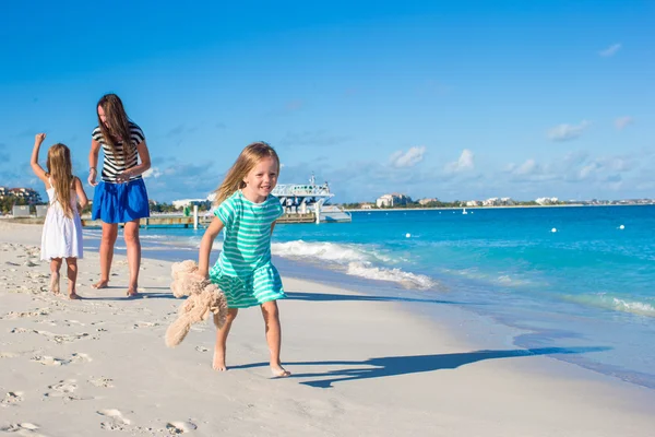 Mother and her little daughters having fun at exotic beach on sunny day — Stock Photo, Image