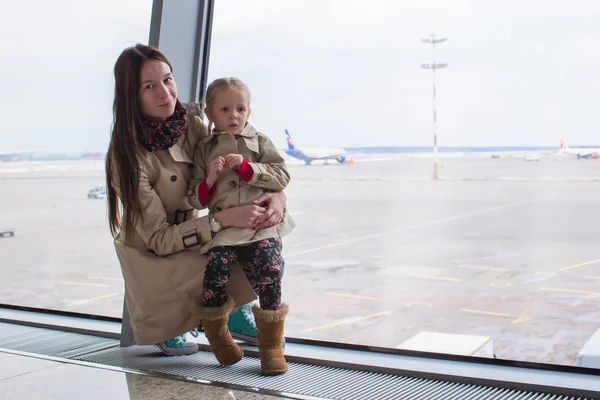 Mor och dotter tittar ut genom fönstret på flygplatsterminalen — Stockfoto