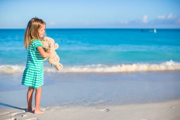 Adorável menina com seu brinquedo coelho em férias de praia tropical — Fotografia de Stock