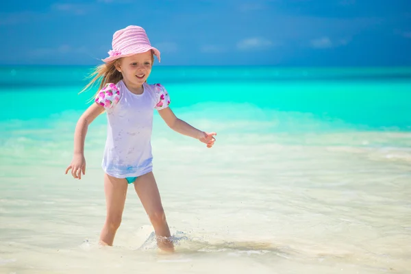 Adorable toddler girl playing in shallow water at exotic beach — Stock Photo, Image