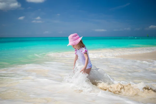 Linda niña jugando en aguas poco profundas en la playa exótica —  Fotos de Stock