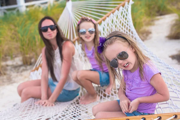 Mãe e filhas pequenas relaxando na rede em férias de verão — Fotografia de Stock