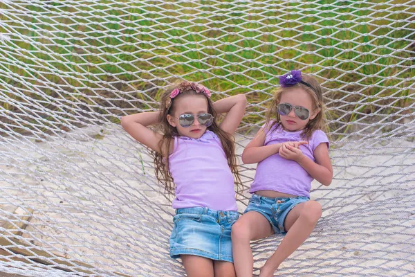 Pequenas meninas doces relaxando na rede em férias de verão — Fotografia de Stock