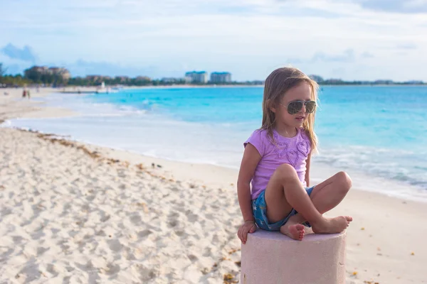 Egzotik bir kumsalda bir lotus pozisyonda oturan sevimli küçük kız — Stok fotoğraf