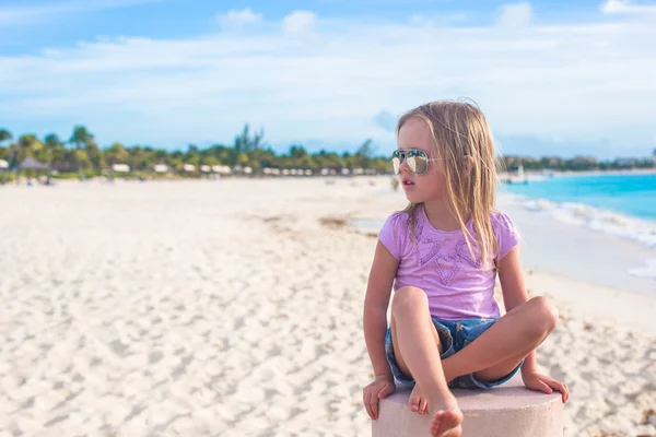 Αξιολάτρευτο κοριτσάκι που κάθεται στην στάση του λωτού σε μια εξωτική παραλία — Φωτογραφία Αρχείου