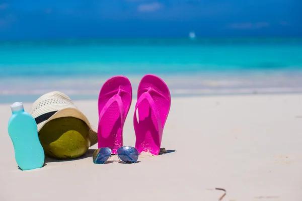 Flip flopy, kokos, klobouk a suncream na bílý písek — Stock fotografie