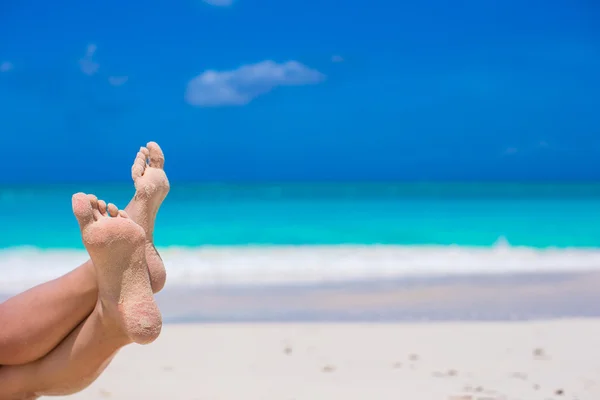 Primer plano de los pies femeninos en la playa de arena blanca —  Fotos de Stock