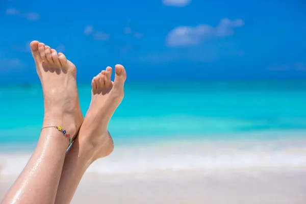 Gros plan des jambes des femmes sur la plage de sable blanc — Photo