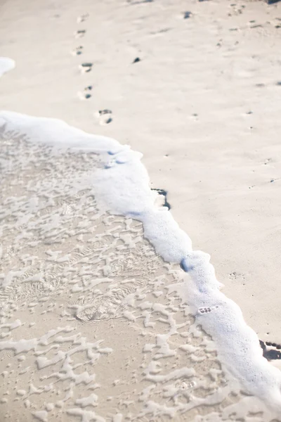 Menschliche Fußabdrücke am weißen Sandstrand — Stockfoto