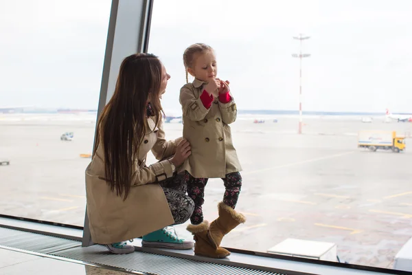 Mor och dotter tittar ut genom fönstret på flygplatsterminalen — Stockfoto