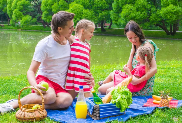 Happy young family picnicking outdoors — Stock Photo, Image