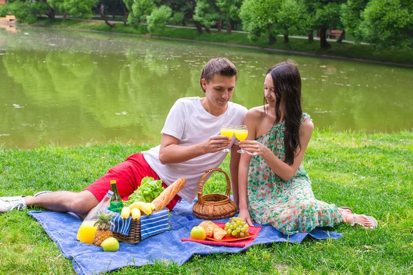 Jonge gelukkige paar picknicken en te ontspannen buitenshuis — Stockfoto