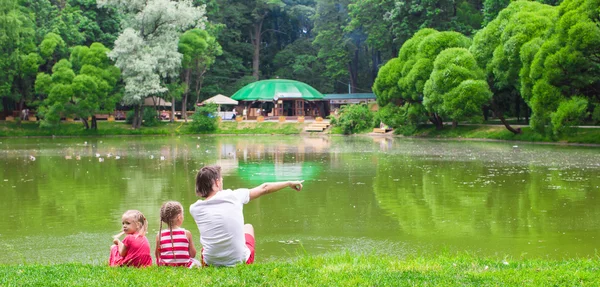 Père heureux et petites filles mignonnes près du lac — Photo