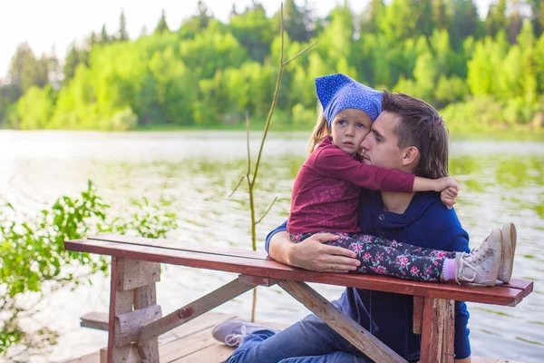 Joven papá y su pequeña hija en el muelle junto al lago —  Fotos de Stock