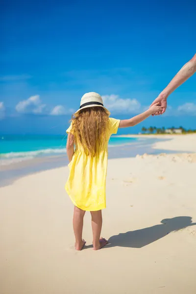 Urocza mała dziewczynka kapelusz trzymając rękę ojca na plaży — Zdjęcie stockowe