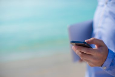 plajda bilgisayar arka plan üzerinde telefon kadar yakın