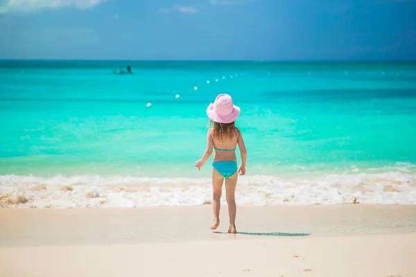 Adorable little girl runing in shallow water at exotic beach — Stock Photo, Image