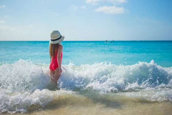 Adorável menina brincando em águas rasas na praia exótica — Fotografia de Stock