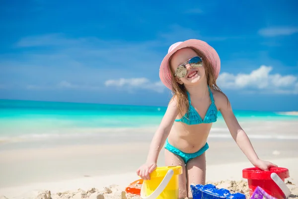 Söt glad tjej leker med leksaker på strandsemester — Stockfoto