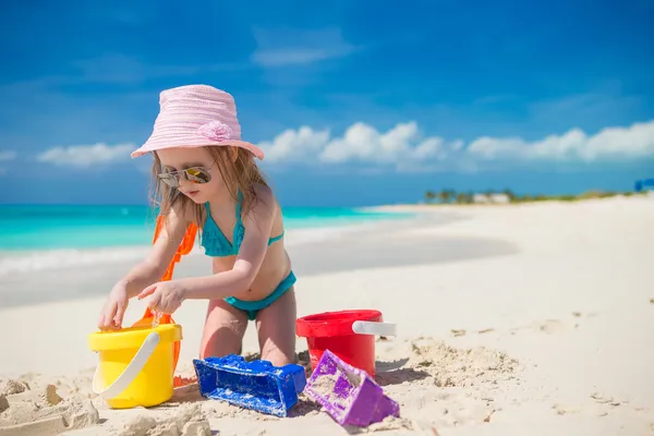 Roztomilé holčička hraje s hračkami na pláži dovolená — Stock fotografie