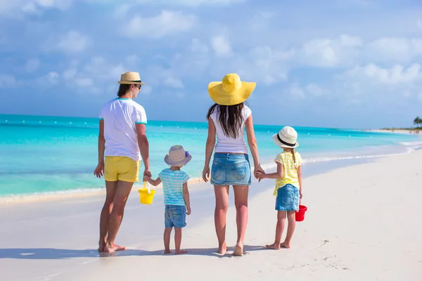 Bakifrån ung familj av fyra på tropical beach — Stockfoto