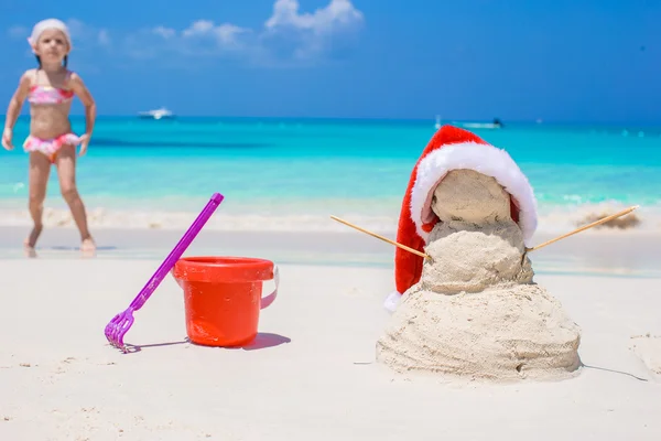 Little sandy snowman with red Santa Hat on white Caribbean beach — Stock Photo, Image