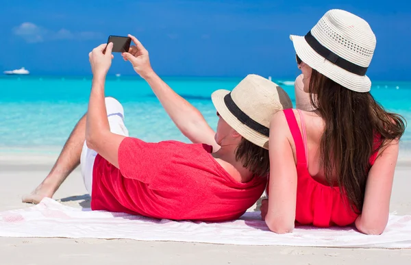 Lyckliga paret själva ta ett foto på tropisk strand — Stockfoto