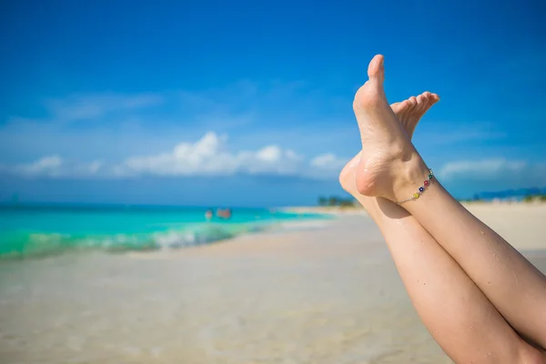 Primer plano de los pies femeninos en la playa de arena blanca — Foto de Stock