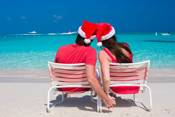 Feliz casal romântico em vermelho Santa Chapéus na praia tropical — Fotografia de Stock