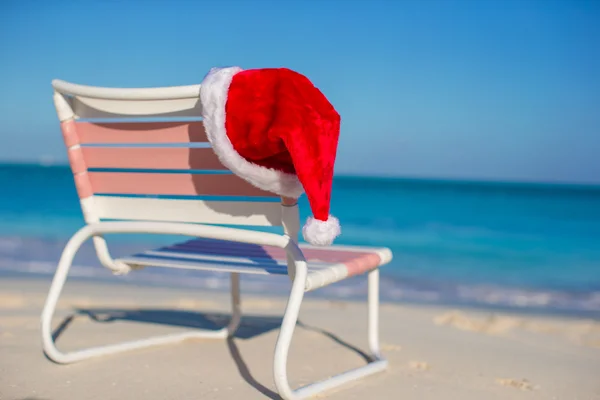 Κοντινό πλάνο καπέλο santa για καρέκλα longue σε τροπική παραλία — Φωτογραφία Αρχείου