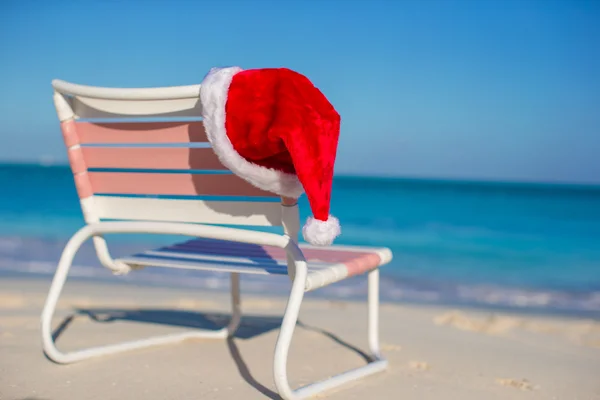 Kerstman hoed op stoel longue op tropisch strand close-up — Stockfoto