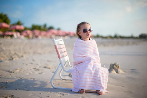 Sevimli küçük kız plaj sandalye üzerinde oturan havlu ile kaplı. — Stok fotoğraf