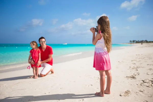 लहान मुलगी समुद्रकिनारी तिच्या कुटुंबाच्या फोनवर फोटो बनविते — स्टॉक फोटो, इमेज