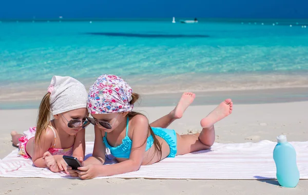 Karayipler tatil sırasında telefon oynarken sevimli kızlar — Stok fotoğraf