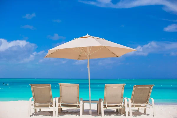 白色遮阳伞和在地处热带的海滩日光浴浴床 — 图库照片