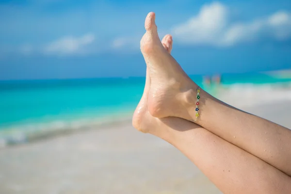 Close up van vrouwelijke voeten op wit zandstrand — Stockfoto