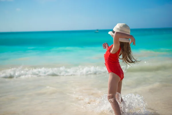 Adorable petite fille jouant en eau peu profonde à la plage exotique — Photo