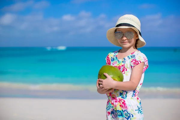 Søte lille jente med kokosnøtt på hvit strand ha det gøy – stockfoto